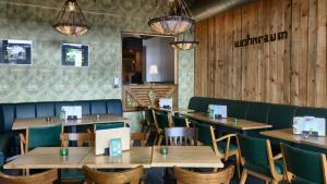 un restaurante con paredes de madera, mesas y sillas de madera en Unperfekthotel, en Essen