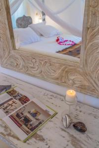 a bedroom with a bed with a mirror and a candle at Alawi Home in Watamu