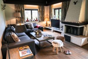 a living room with a couch and a fireplace at Steinberghaus Ferienhaus in Leogang