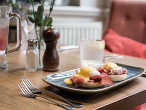 a plate of food on a table with a sandwich at The Fleece at Cirencester in Cirencester