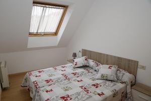 a bedroom with a bed with a blanket and pillows at Alojamiento Caldas de Reis in Caldas de Reis