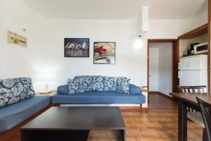 a living room with a blue couch and a table at Apartamentos Don Pedro in Playa del Ingles