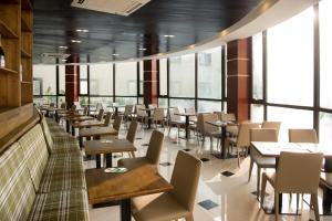 un comedor con mesas, sillas y ventanas en The Farmington Hotel en Harbel