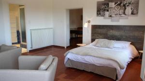 Un dormitorio con una cama, un sofá y una silla. en le clos du Patre, en Caromb