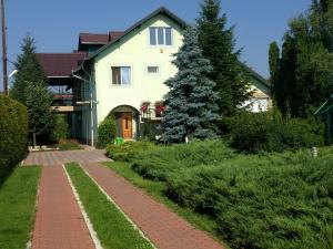 a house with a brick walkway in front of it at Casa cu pauni in Mărăcineni