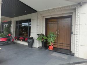 einer Eingangstür eines Gebäudes mit Topfpflanzen in der Unterkunft Happy Hostel in Lukang + 18 Fotos