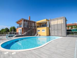 a villa with a swimming pool in front of a house at Apartment in Funtana with Three-Bedrooms 1 in Funtana