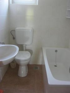 a bathroom with a toilet and a sink and a tub at Apartment Maskarin Rab in Mundanije +10 photos