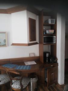 a kitchen with a wooden table and a microwave at Landhaus Enzensberg in Füssen