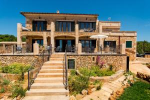 a stone house with stairs leading up to it at Agroturismo Sa Marina in Alquería Blanca