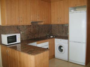cocina con nevera blanca y microondas en Apartamento con aire acondicionado en 1ª linea de playa edificio Molí de Vent, en Peñíscola