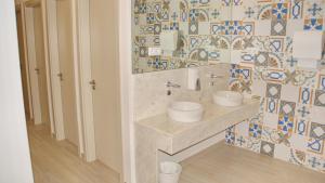 a bathroom with two sinks and a tiled wall at Topcity Hostel & Suites in Lagos