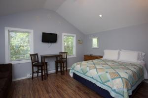 a bedroom with a bed and a table and chairs at Drake's Island Resort & Cottages in Wells +23 photos