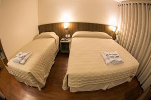 2 letti in camera d'albergo con asciugamani di Hotel Dom Rafael Premium a Santa Maria