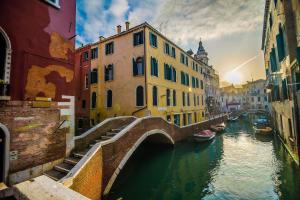 威尼斯的住宿－迪莫那多加爾旅館，一座有船的城市运河上的桥梁