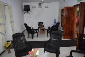 a waiting room with black chairs and a tv at Nest Inn in Trincomalee
