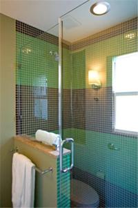 a bathroom with a green tiled shower with a glass door at Truman Hotel in Key West
