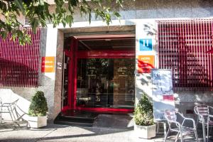 a red door of a building with chairs and tables at Hotel Villa de Zaragoza in Casetas