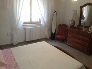カステルサルドにあるCasa Castelsardoのベッドルーム(ドレッサー、鏡、椅子付)