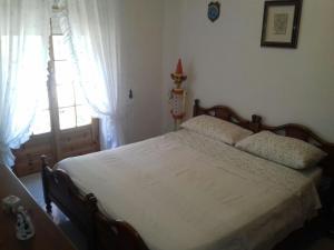 カステルサルドにあるCasa Castelsardoのベッドルーム(ベッド1台、窓付)