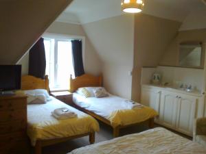 1 dormitorio con 2 camas y ventana en Kingsley Hotel, en Bournemouth