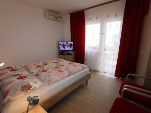 a bedroom with a bed and a tv and a window at Apartment in Silo/Insel Krk 13439 in Šilo
