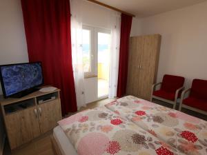 a small bedroom with a bed and a television at Apartment in Silo/Insel Krk 13439 in Šilo