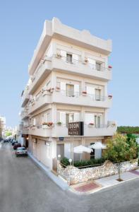 un gran edificio blanco con un cartel delante en Hotel Ideon, en La Canea