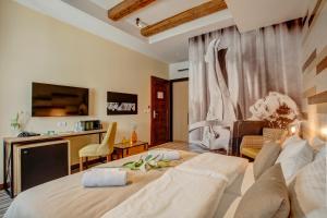 a bedroom with a large bed and a living room at Garni Hotel Zavicaj in Belgrade