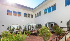 a large white building with a patio with people sitting at Tokajvár Hotel in Tokaj