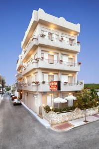 een hoog wit gebouw met een bord ervoor bij Hotel Ideon in Chania