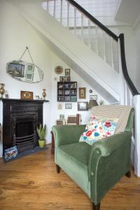 a green couch in a living room with a staircase at The Dolls House in Wexford