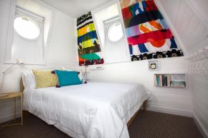 1 dormitorio con 1 cama blanca y 2 ventanas en The Dolls House, en Wexford