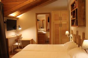 een slaapkamer met een wit bed en een badkamer bij Le jardin de Pierre in Nus