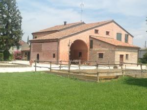 ein großes Backsteingebäude mit einem Zaun davor in der Unterkunft Agriturismo Olianina in Villa Poma