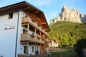a building with a balcony with a mountain in the background at Haus Bernard in Siusi