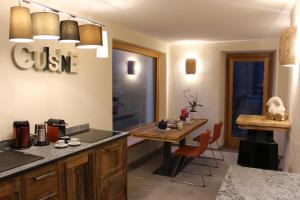 een keuken met een tafel en een eetkamer bij Le jardin de Pierre in Nus +13 foto's