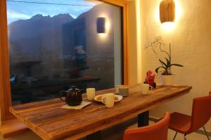a table in a room with a view of a mountain at Le jardin de Pierre in Nus +16 photos