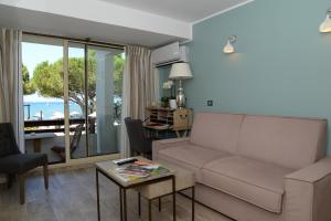 a living room with a couch and a table at Hôtel La Roya in Saint-Florent