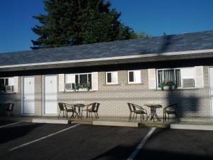 a group of chairs and a table in front of a building at Motel Montgolfière JP in Saint-Jean-sur-Richelieu