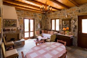 salon ze stołem i kamienną ścianą w obiekcie Athena Villas Olive Grove & Estate w mieście Guwes