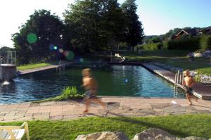 two men are walking by a swimming pool at Landgasthof Paradies in Frickingen