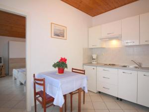kuchnia ze stołem, na którym stoi wazon z kwiatami w obiekcie Apartment in Porec - Istrien 9922 w Poreču