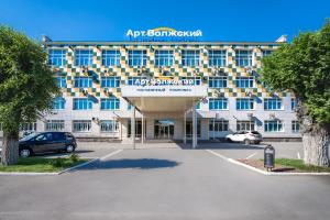un grand bâtiment avec un parking en face de celui-ci dans l'établissement Аrt-Volzhskiy, à Voljski