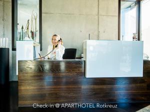 a woman talking on a cell phone in an office at Hotel Bauernhof - Self Check-In Hotel in Rotkreuz