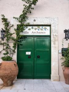 una porta verde di un edificio con un cartello sopra di Villa Archanes ad Archanes
