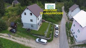 una grande casa bianca con macchine parcheggiate in un cortile di Underwoods Žabljak Guesthouse a Žabljak
