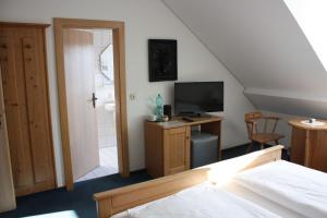 a bedroom with a bed and a television and a staircase at Ferienunterkunft Landshut-Altdorf in Landshut