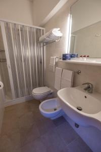 ein Bad mit einem Waschbecken, einem WC und einer Dusche in der Unterkunft Hotel Lilly in Marina di Campo