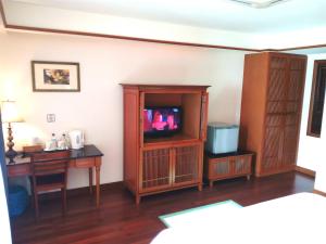 a living room with a tv and a desk at Wonderland Private Chalet at Port Dickson in Port Dickson
